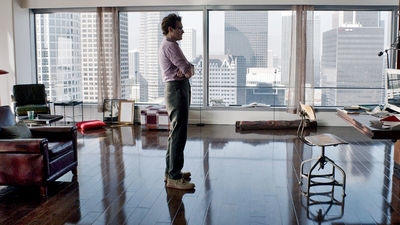 a man standing in a living room looking out a window