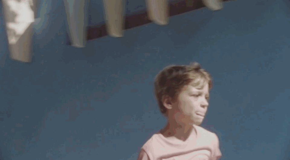 a young boy holding a tennis racquet on a tennis court