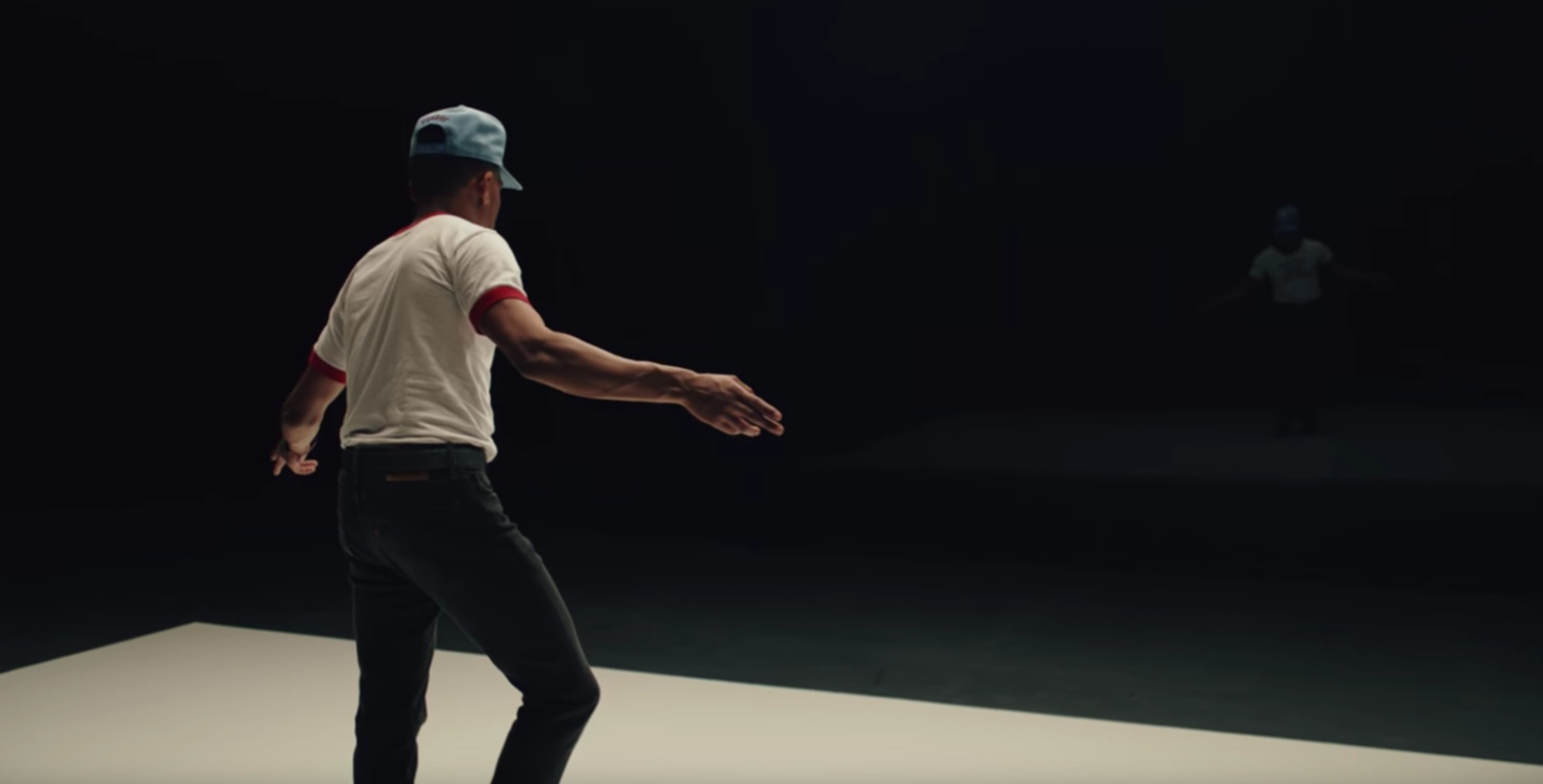 a man in a white shirt and blue hat is skateboarding