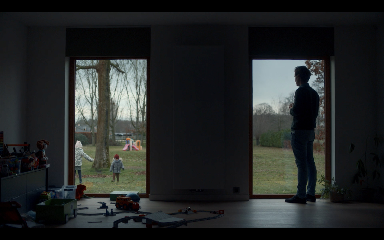 a man standing in a living room next to a window