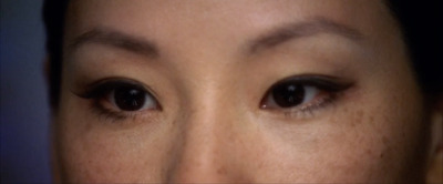 a close up of a woman's face with dark brown eyes