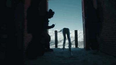 a silhouette of a person standing in front of a gate