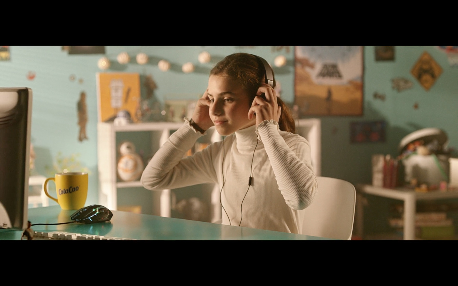 a woman sitting at a desk with headphones in her ears