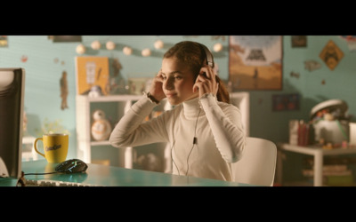 a woman sitting at a desk with headphones in her ears