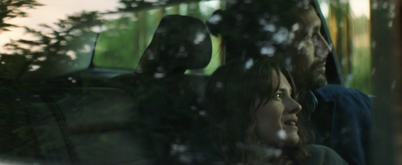 a man and a woman sitting in a car