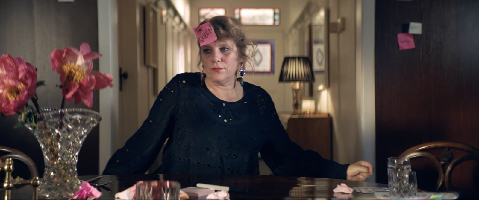 a woman sitting at a table with a pink flower in her hair