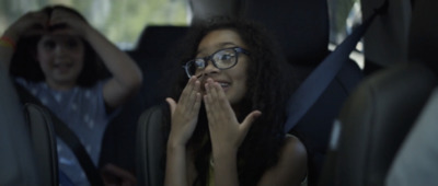 a woman sitting in the back of a car with her hands on her face