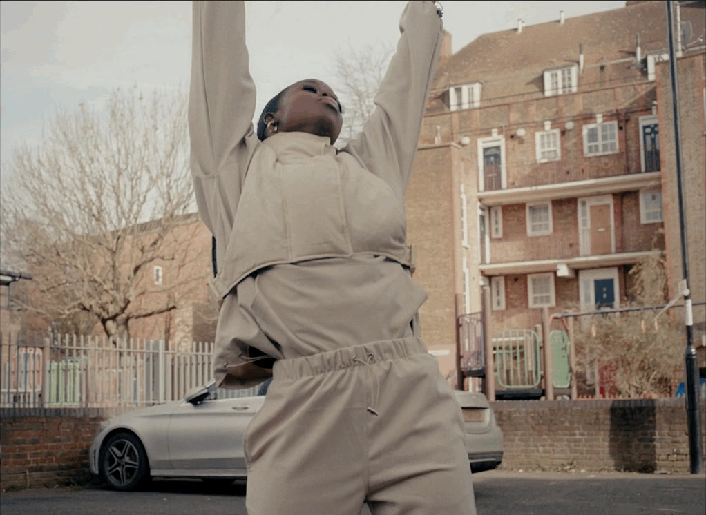 a woman standing in the middle of a street with her arms in the air