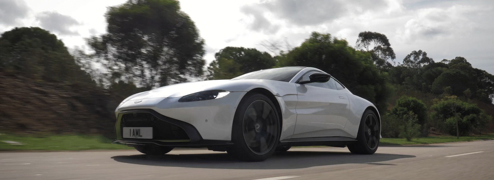 a white sports car driving down a road