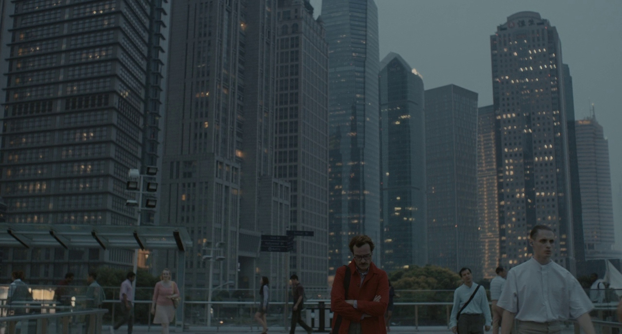 a group of people walking across a bridge next to tall buildings