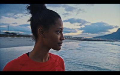 a woman standing in front of a body of water