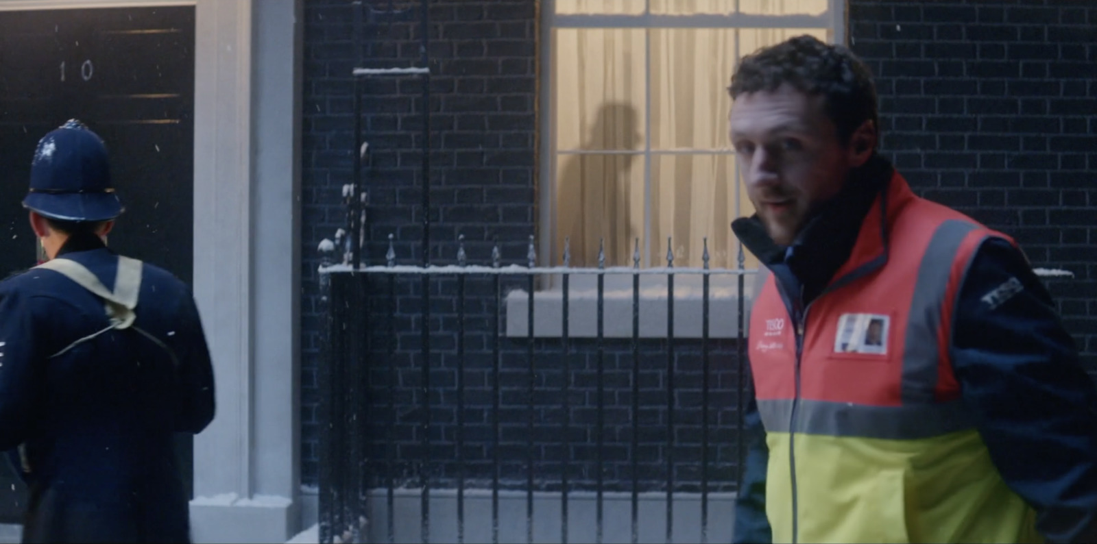 a man in a safety vest standing in front of a building