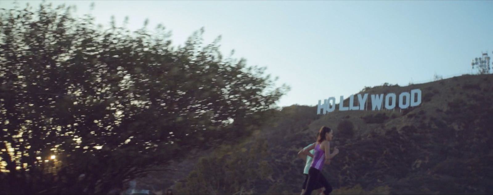 a woman in a purple shirt is flying a kite