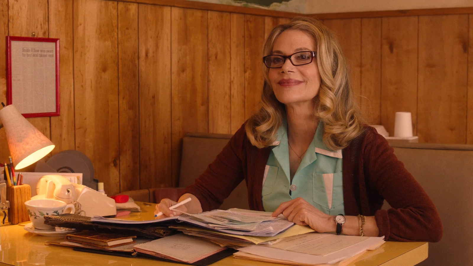 a woman sitting at a desk with a book