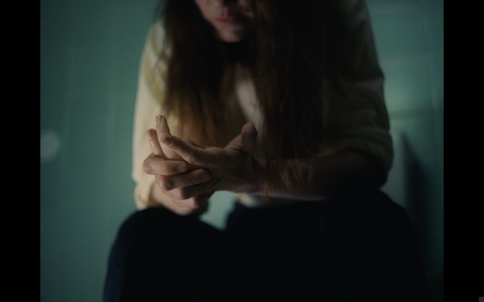 a woman sitting on the floor with her hands together