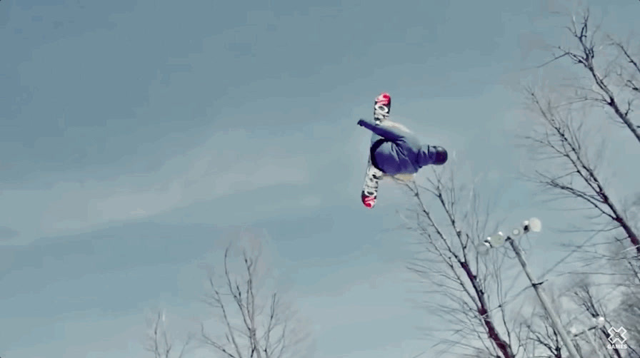 a man flying through the air while riding a snowboard