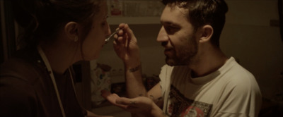 a man is feeding a woman something with a spoon