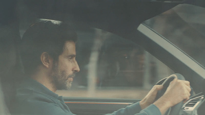 a man sitting in a car holding a steering wheel