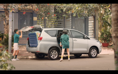 a woman standing in front of a silver van