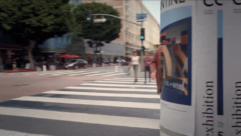 two people walking across a crosswalk in a city