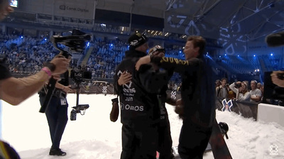 a group of people taking pictures of a snowboarder
