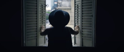 a person standing in front of a window with shutters open