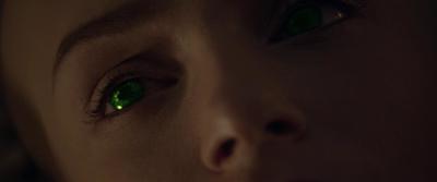 a close up of a woman's face with green eyes