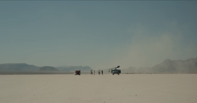 a group of people standing in the middle of a desert