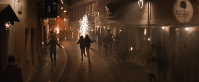 a group of people walking down a street at night