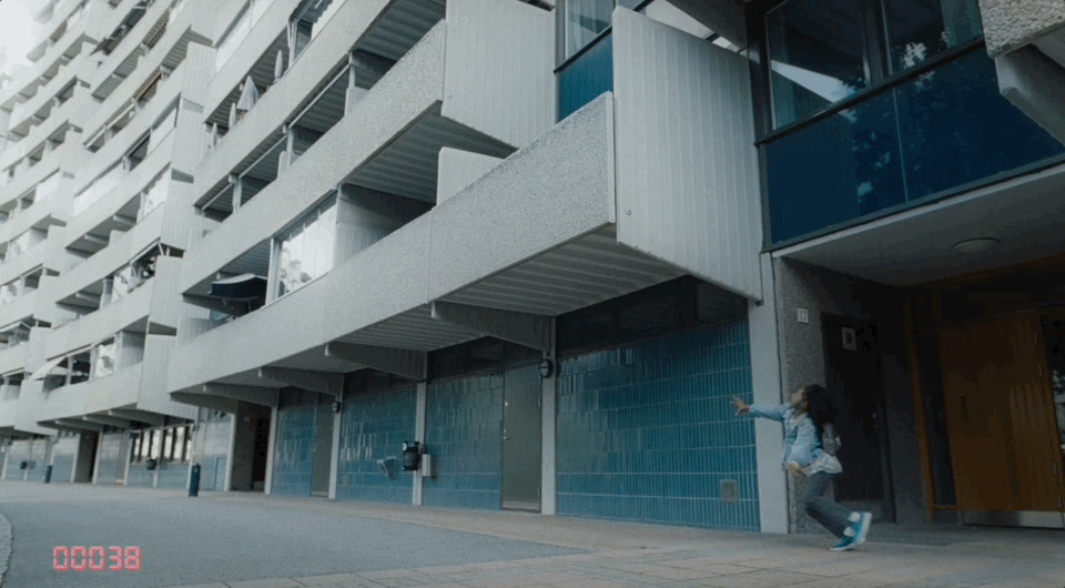 a person jumping in the air in front of a building