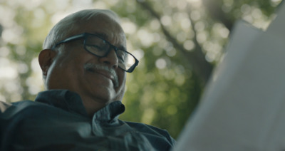 an older man with glasses reading a book