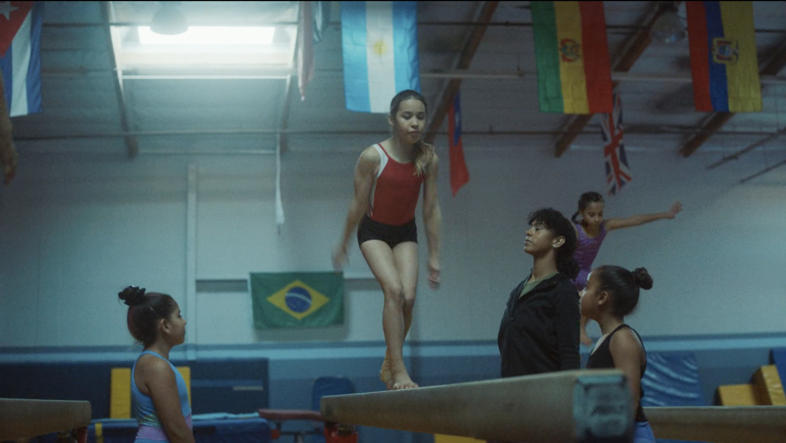 a group of young women standing on top of a balance beam