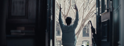 a woman standing in a doorway with her arms in the air