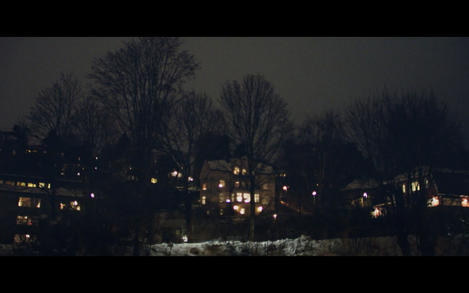 a night time view of a town with a clock tower