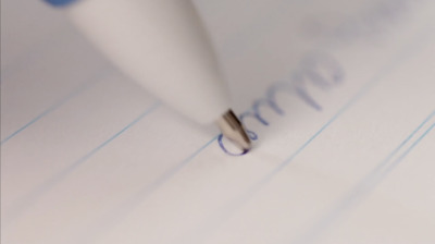 a close up of a pen writing on a piece of paper