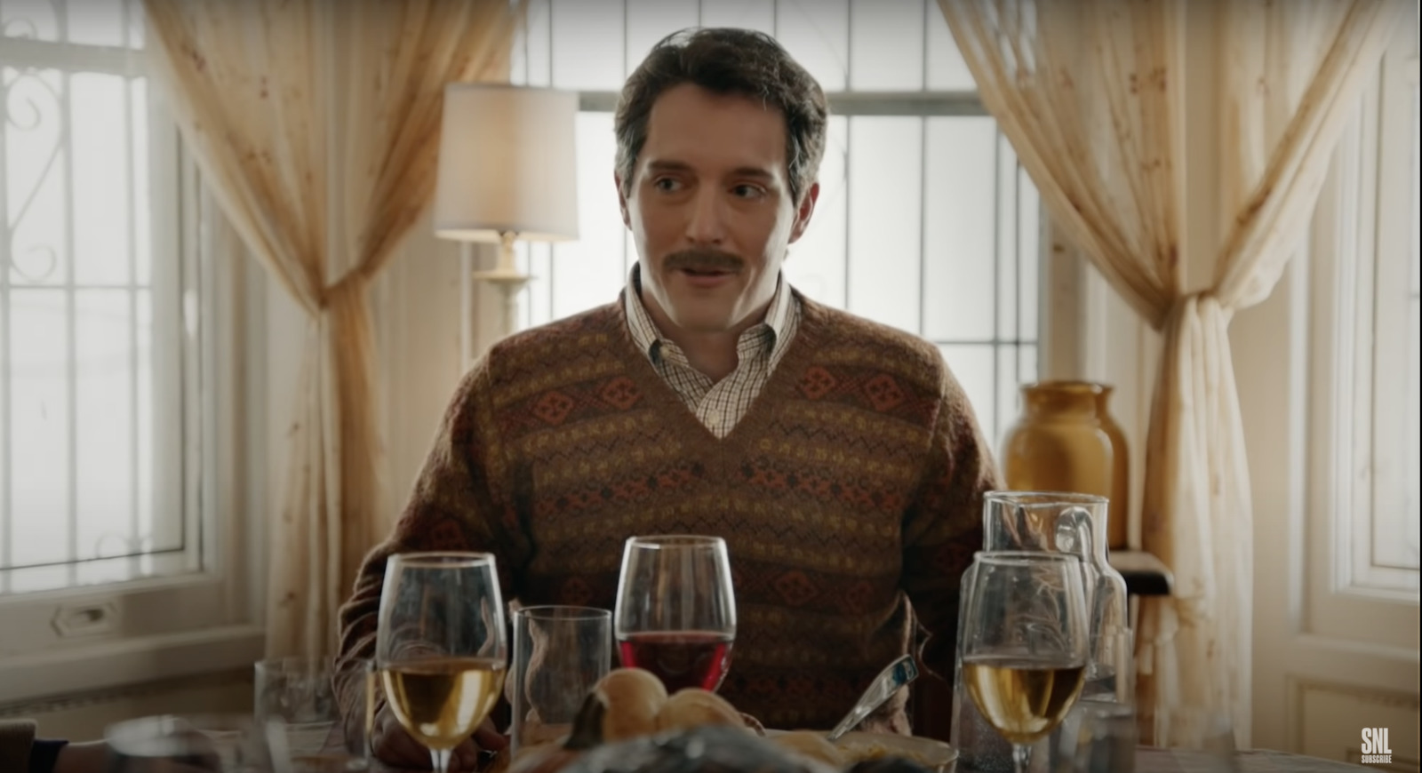 a man sitting at a table with glasses of wine