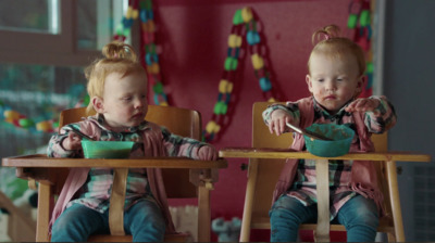 two young children sitting at a table eating