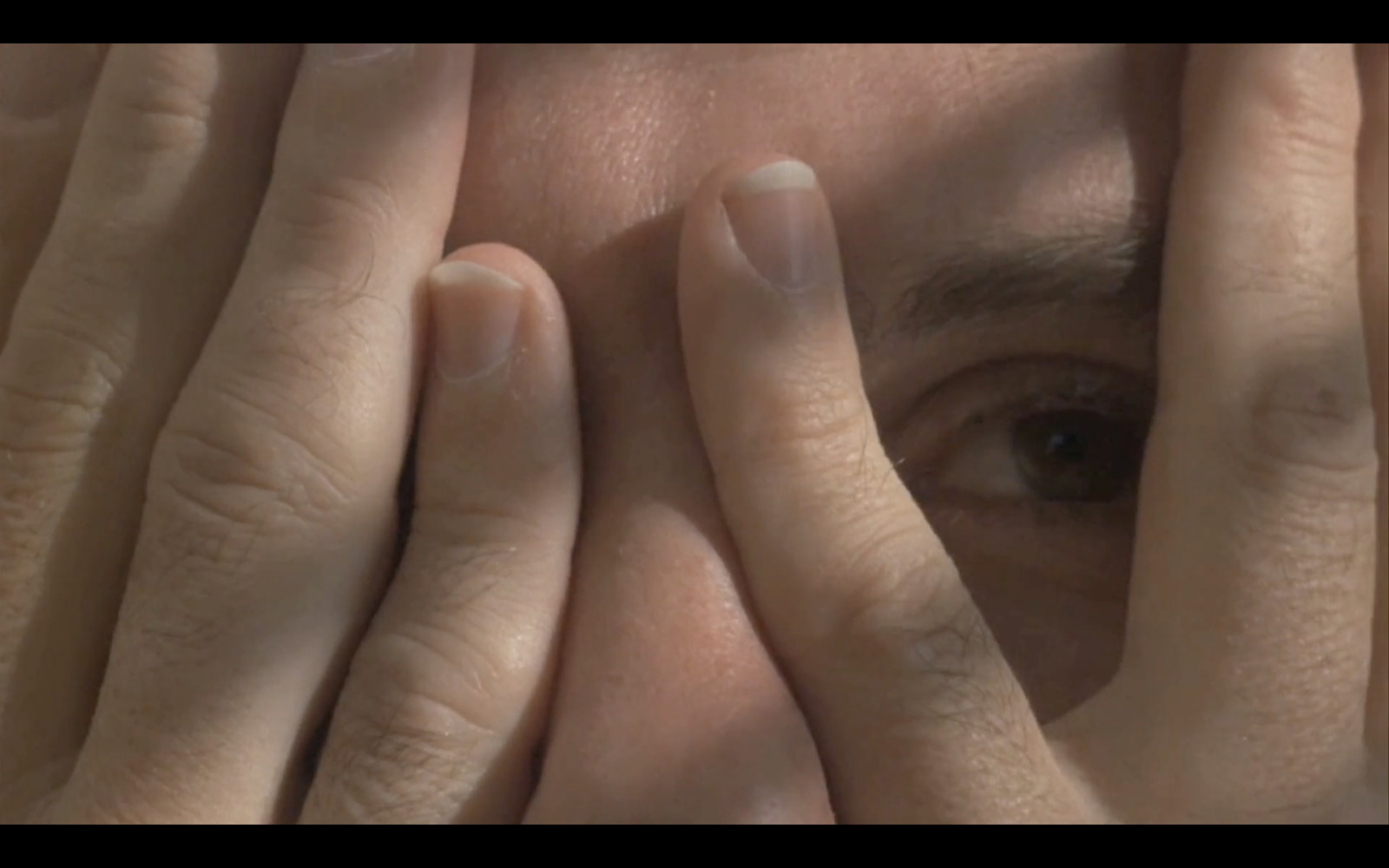 a close up of a person covering their eyes