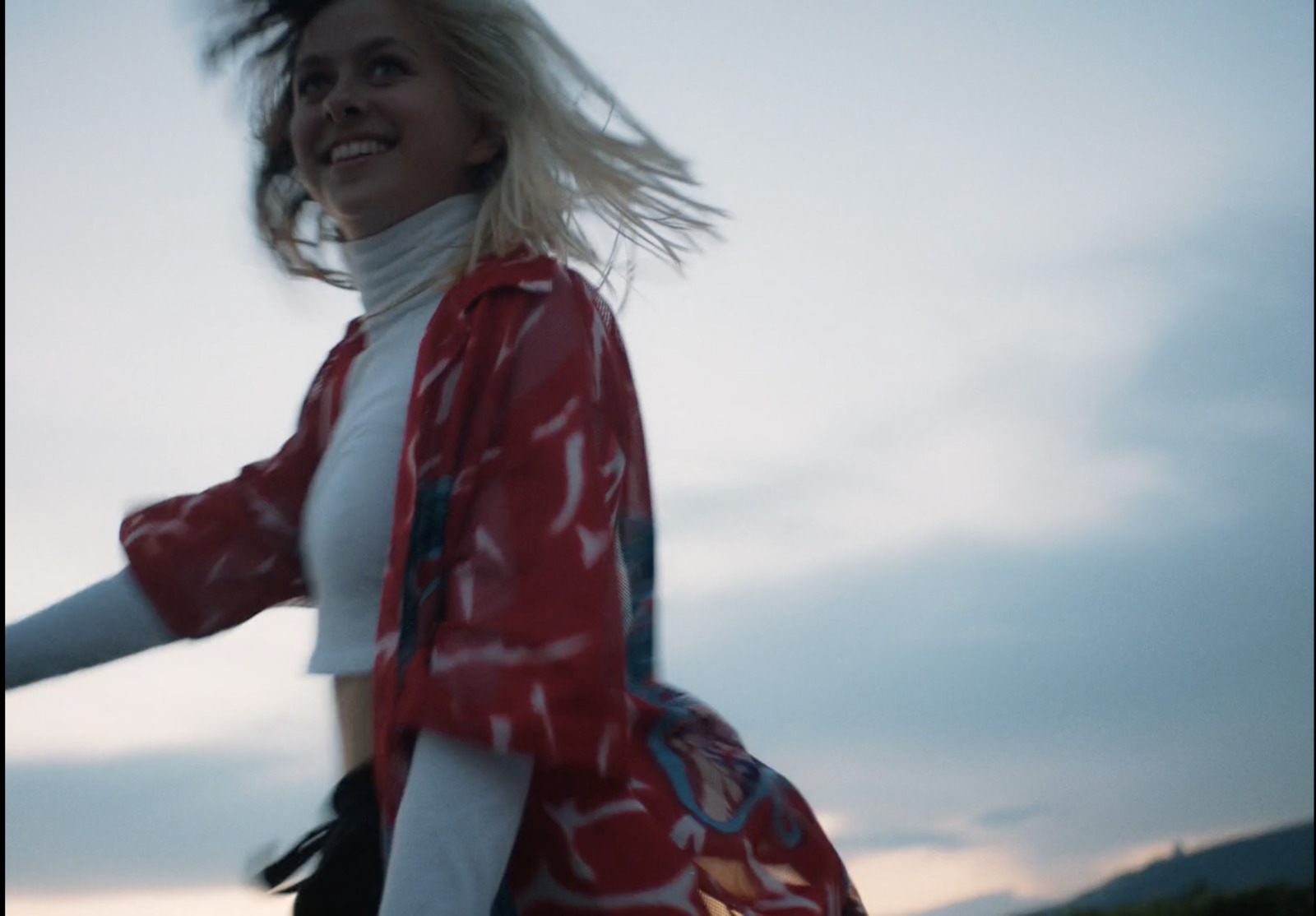 a woman in a red jacket and white shirt