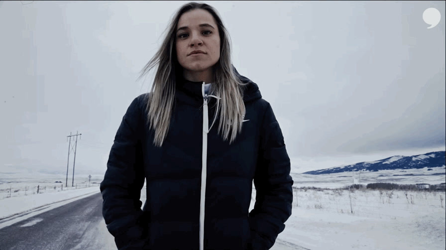 a woman standing in the middle of a snowy road