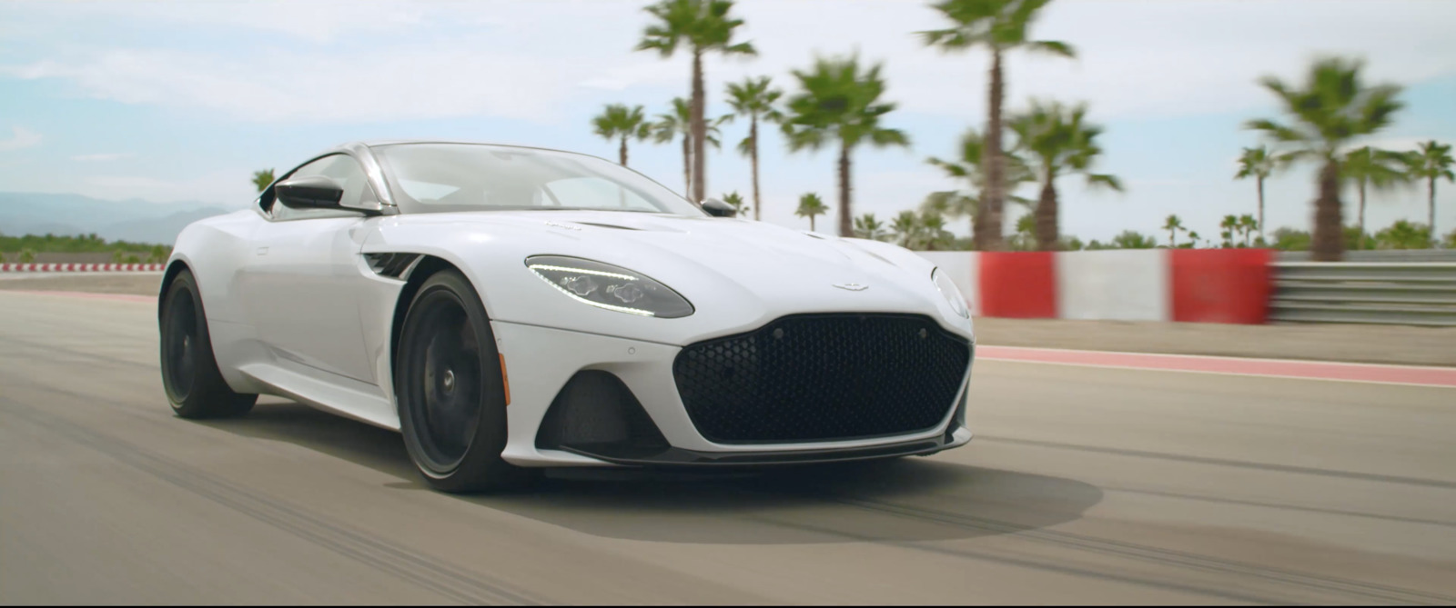 a white sports car driving down a race track