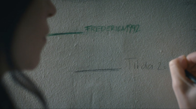 a woman writing on a wall with a marker