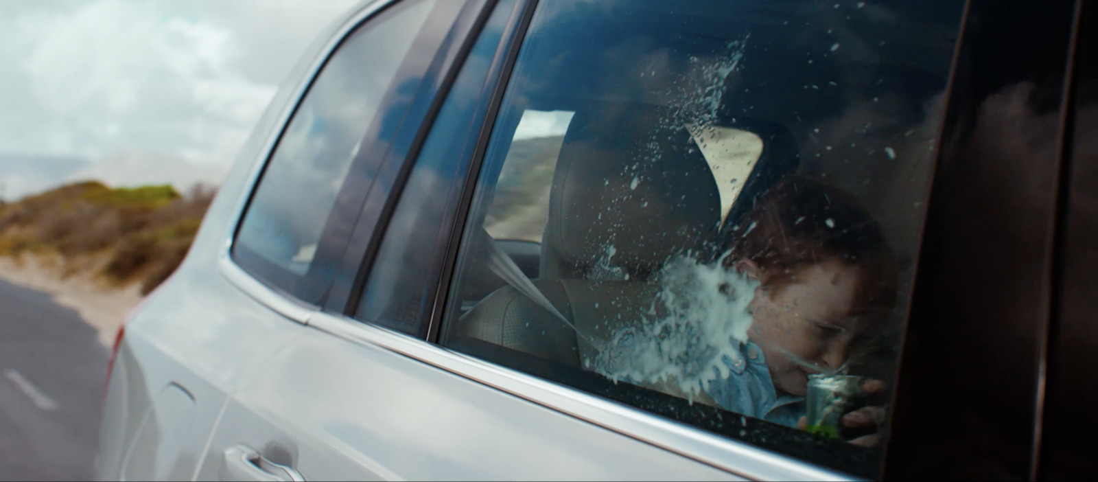 a young boy sitting in the passenger seat of a car