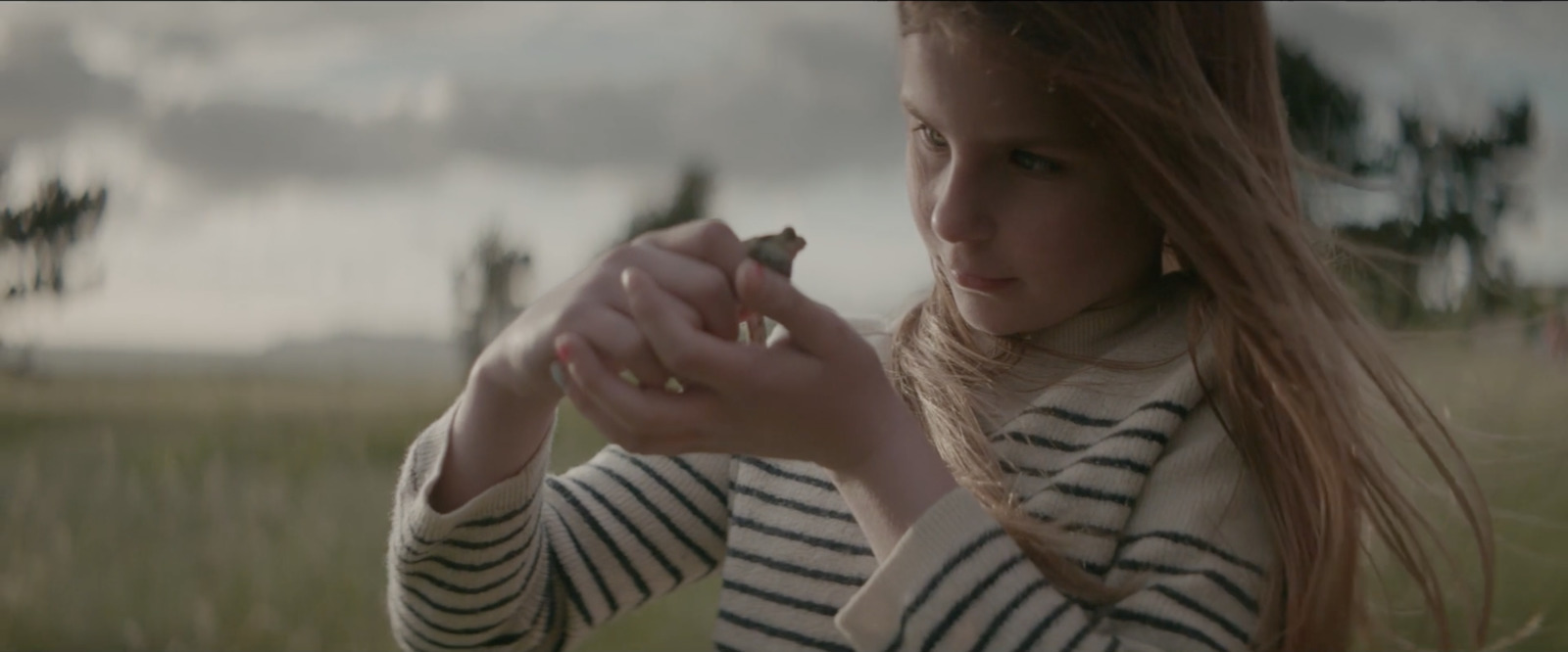 a girl in a striped shirt is holding a cigarette