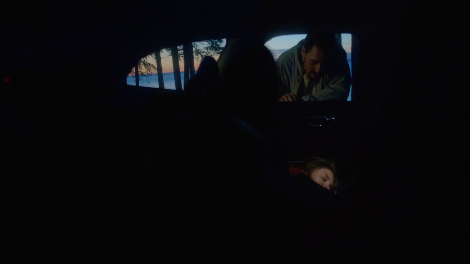 a man sitting in the back seat of a car in the dark