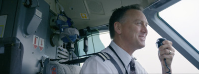 a man in a pilot's uniform holding a camera