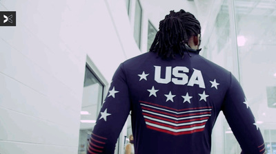 a man with dreadlocks walking down a hallway