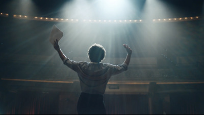 a man standing in front of a stage with his hands up