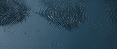 a close up of a water surface with rain drops