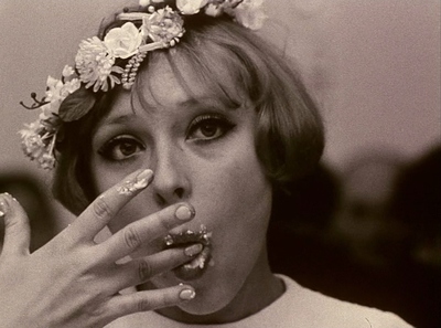 a woman with a flower crown on her head smoking a cigarette